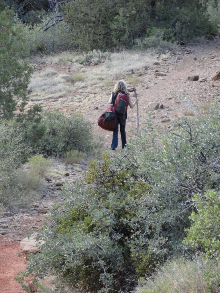 A single person with pack hiking in nature illustrates heading out on a solo overnight vision quest ceremony in nature