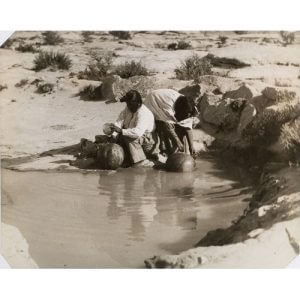 Historic photo of Hopi women filling water jugs. Hopis believe all waters are sacred and that humankind is a participant in water-life.